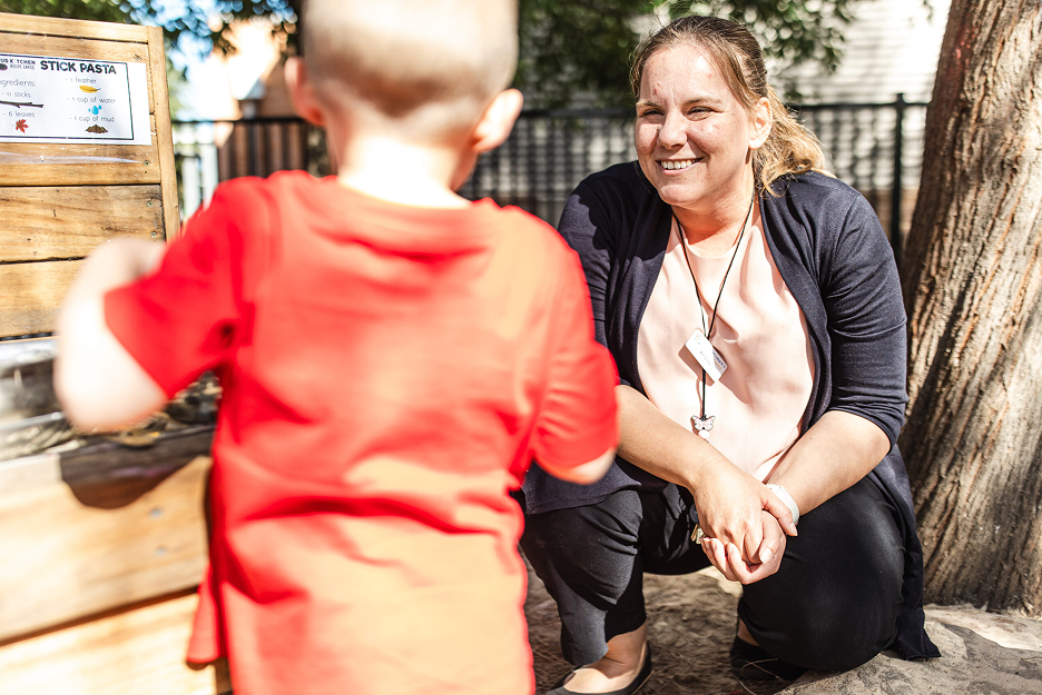 Educator with a young child in the Children's Centre outdoor play area