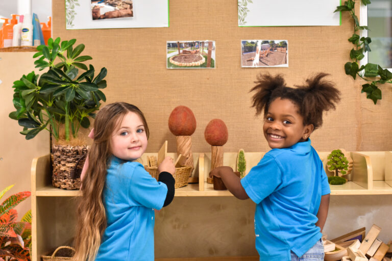 Two Children's Centre students playing at a nature play shelf