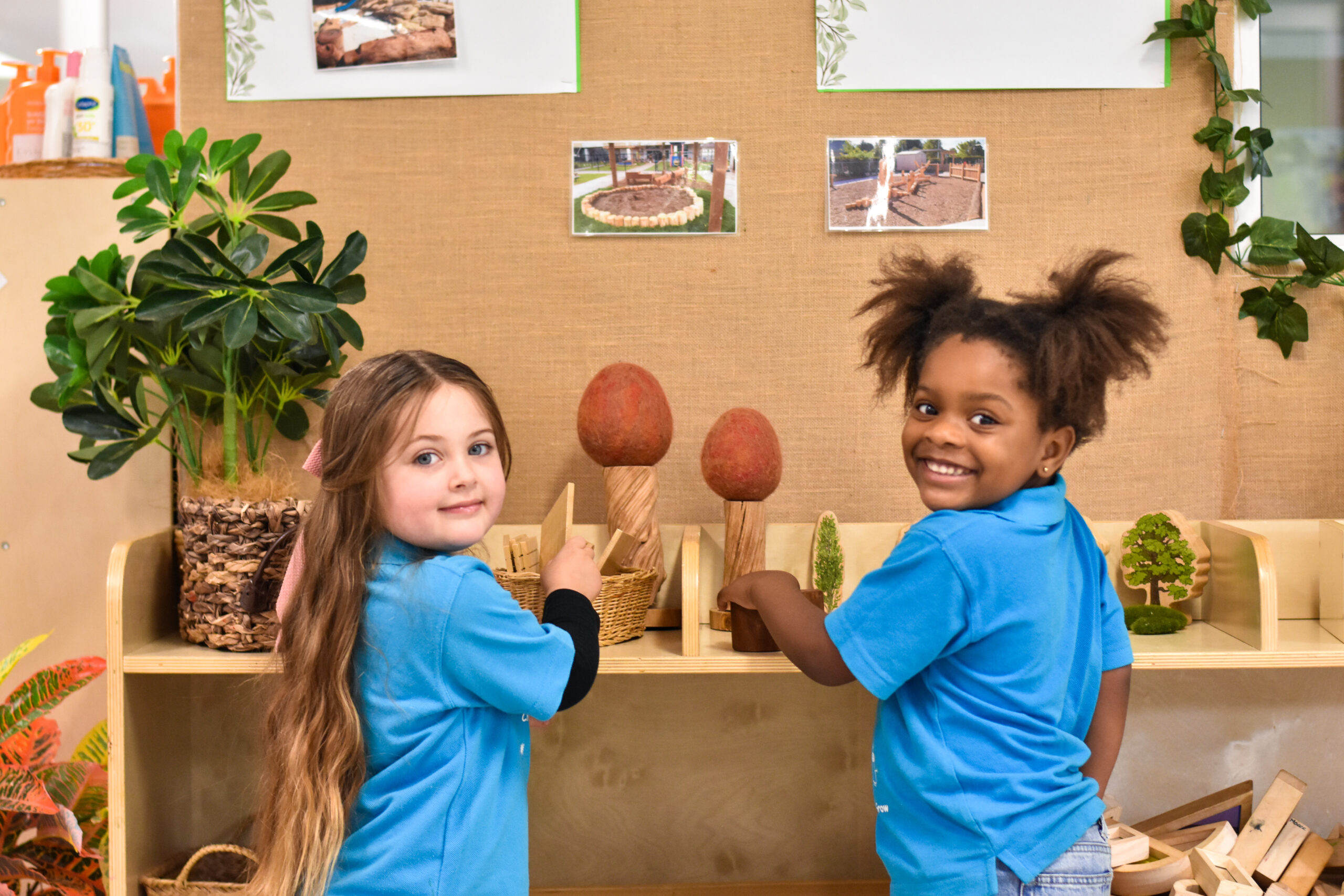Two Children's Centre students playing at a nature play shelf