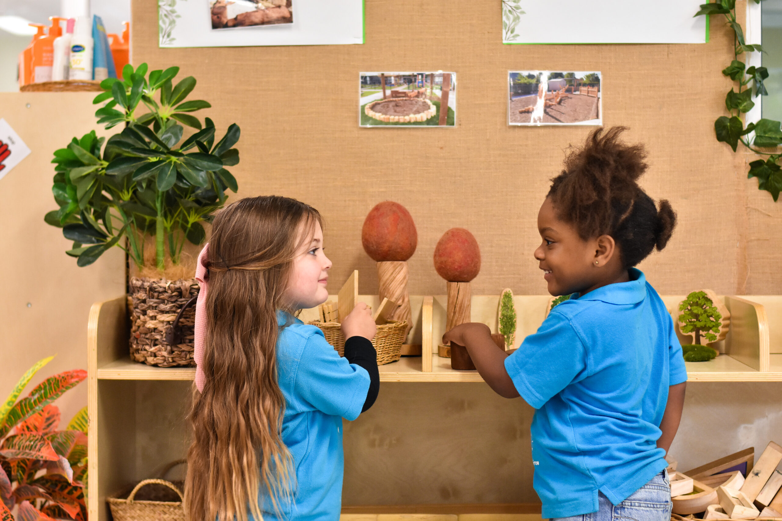 Children's Centre students playing at a nature play shelf