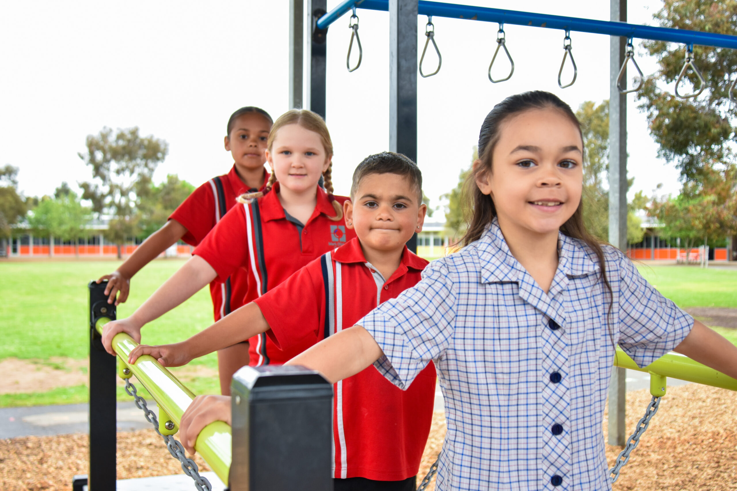 Primary students playing on the outdoor playground equipment