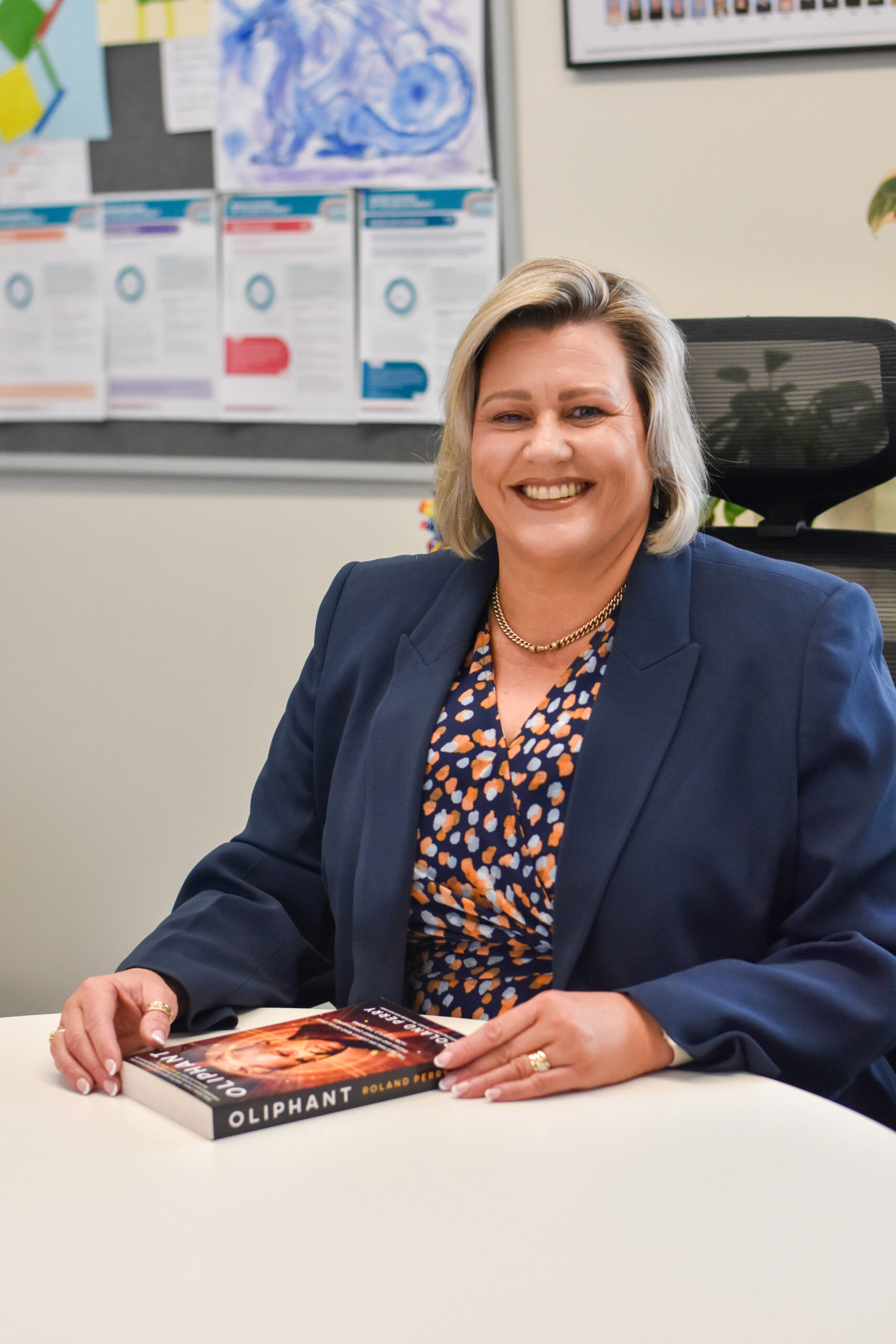Kerry Williams, Principal of Mark Oliphant College, seated at a desk