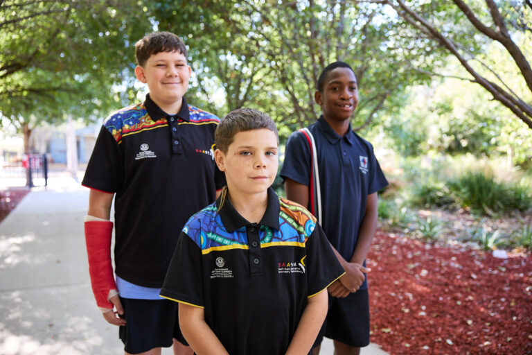 Three students standing together in the school grounds