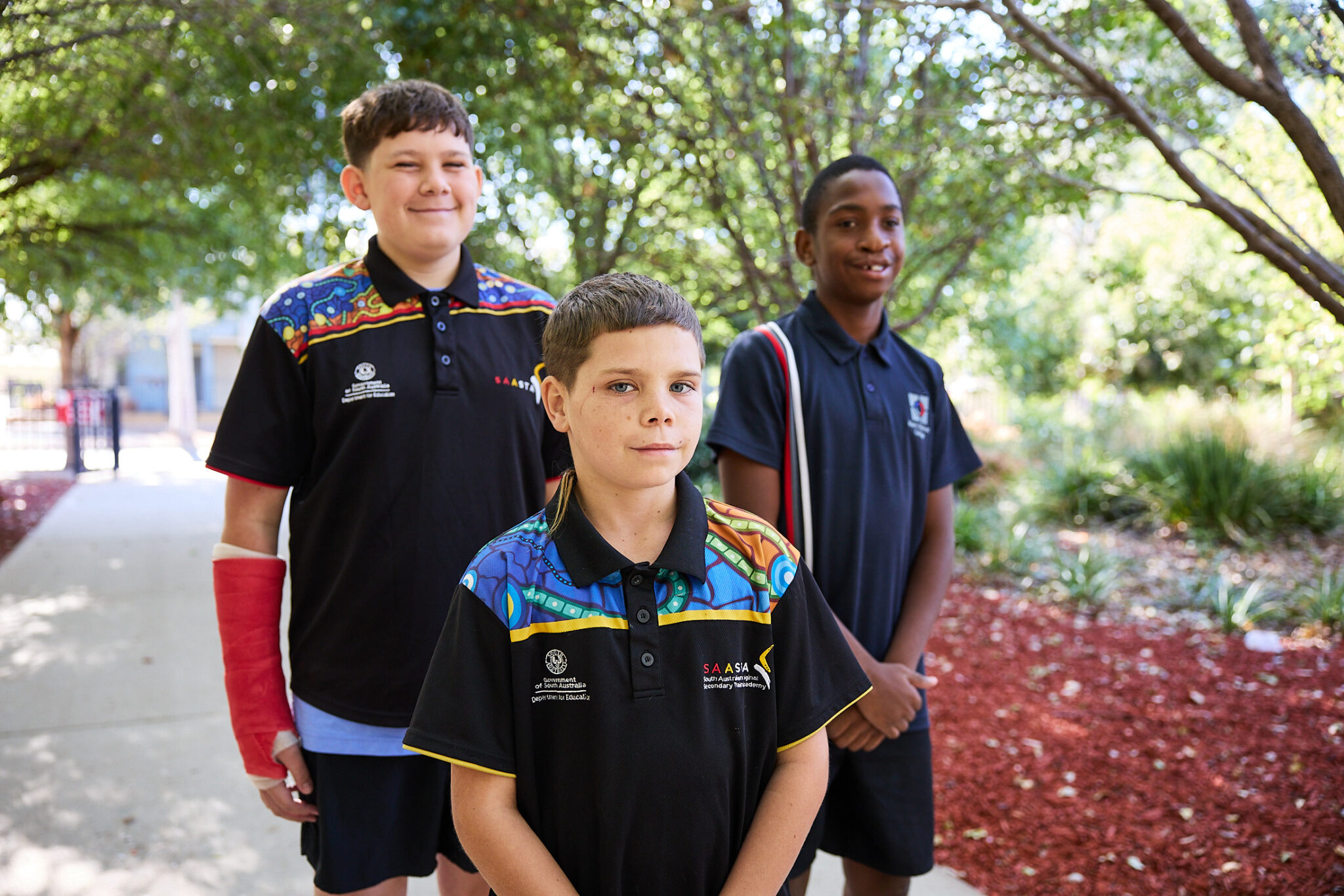 Three students standing together in the school grounds