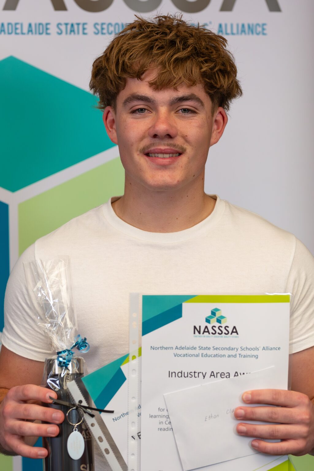 Student holding a NASSSA industry award certificate and trophy
