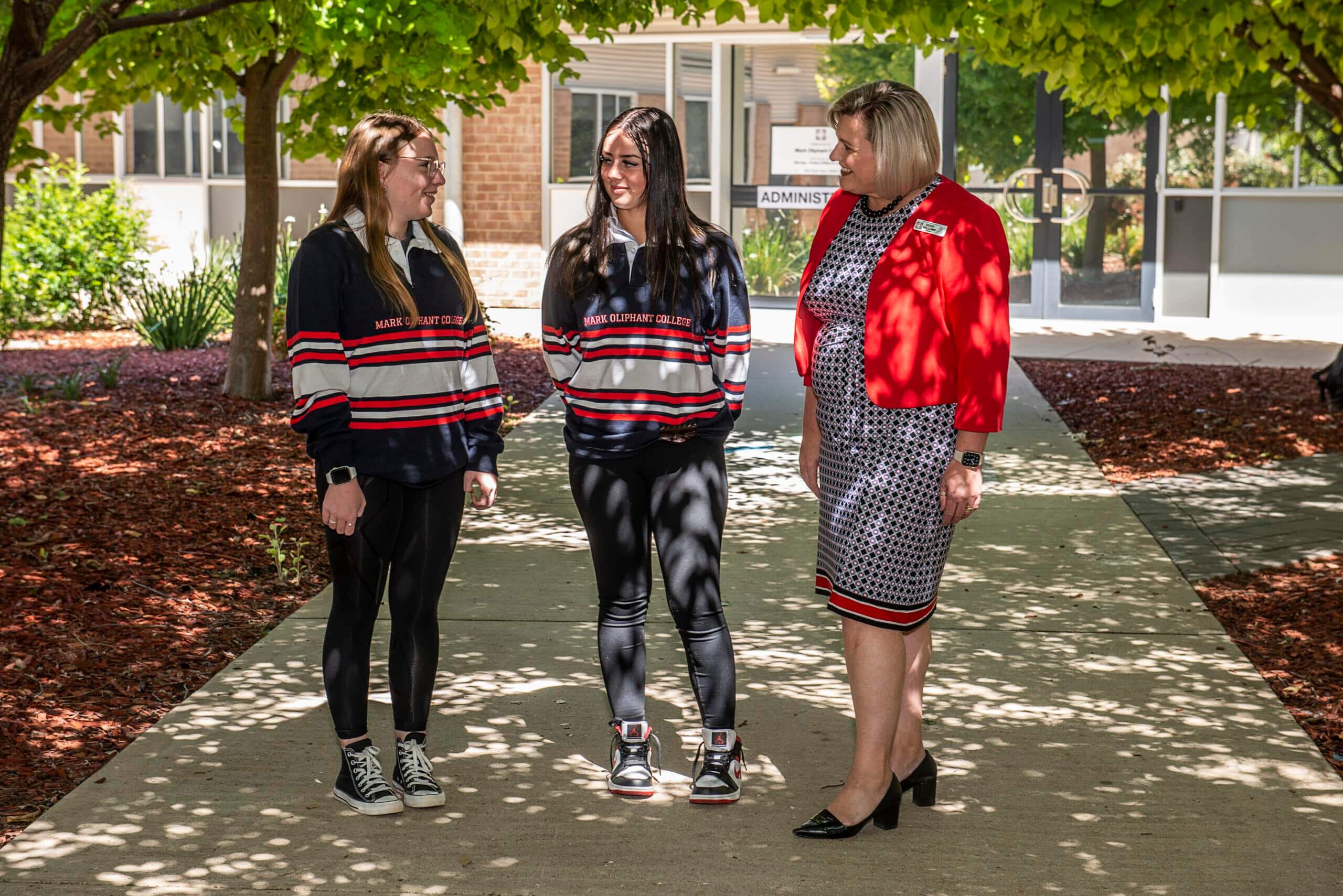Students in Mark Oliphant College jackets walking with a staff member