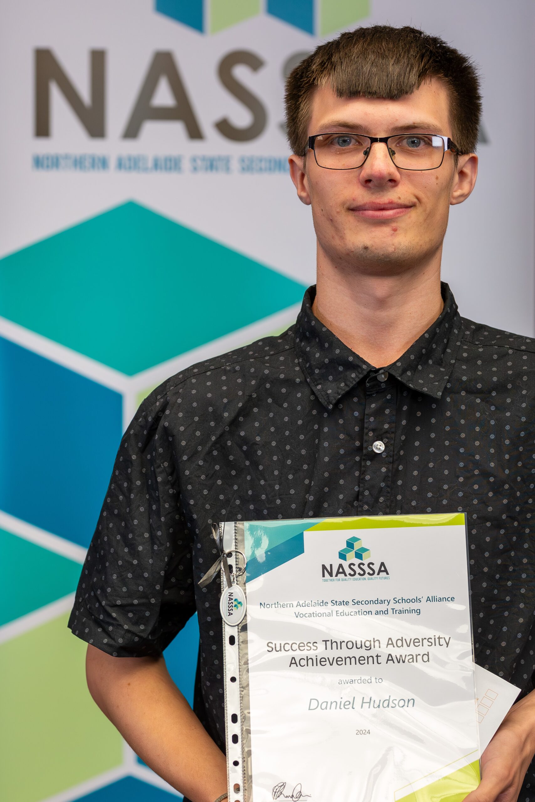 Student holding a NASSSA Success Through Adversity Achievement Award certificate