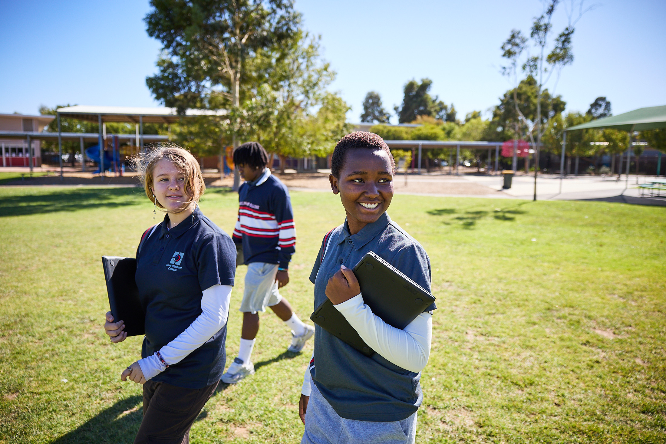 Secondary students walking across the school oval