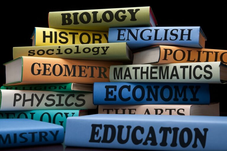 Stack of textbooks labelled with school subjects