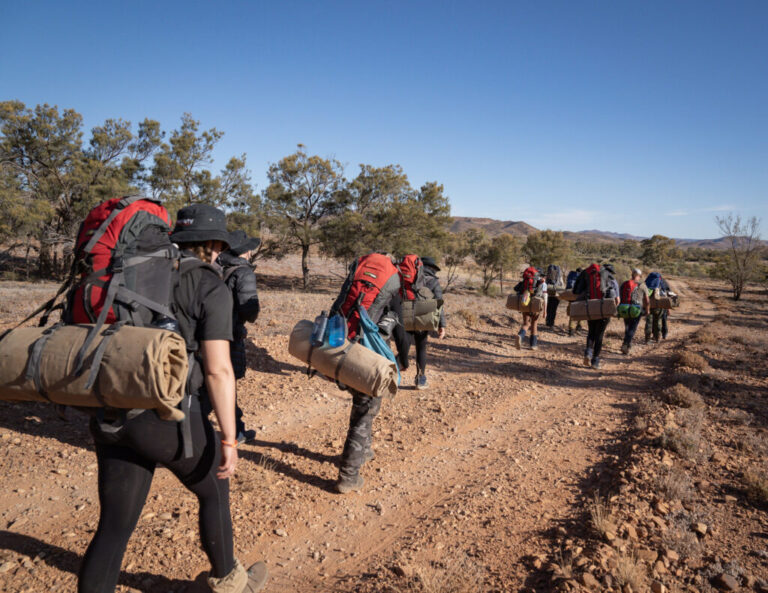 Students hiking with packs during an outdoor education camp