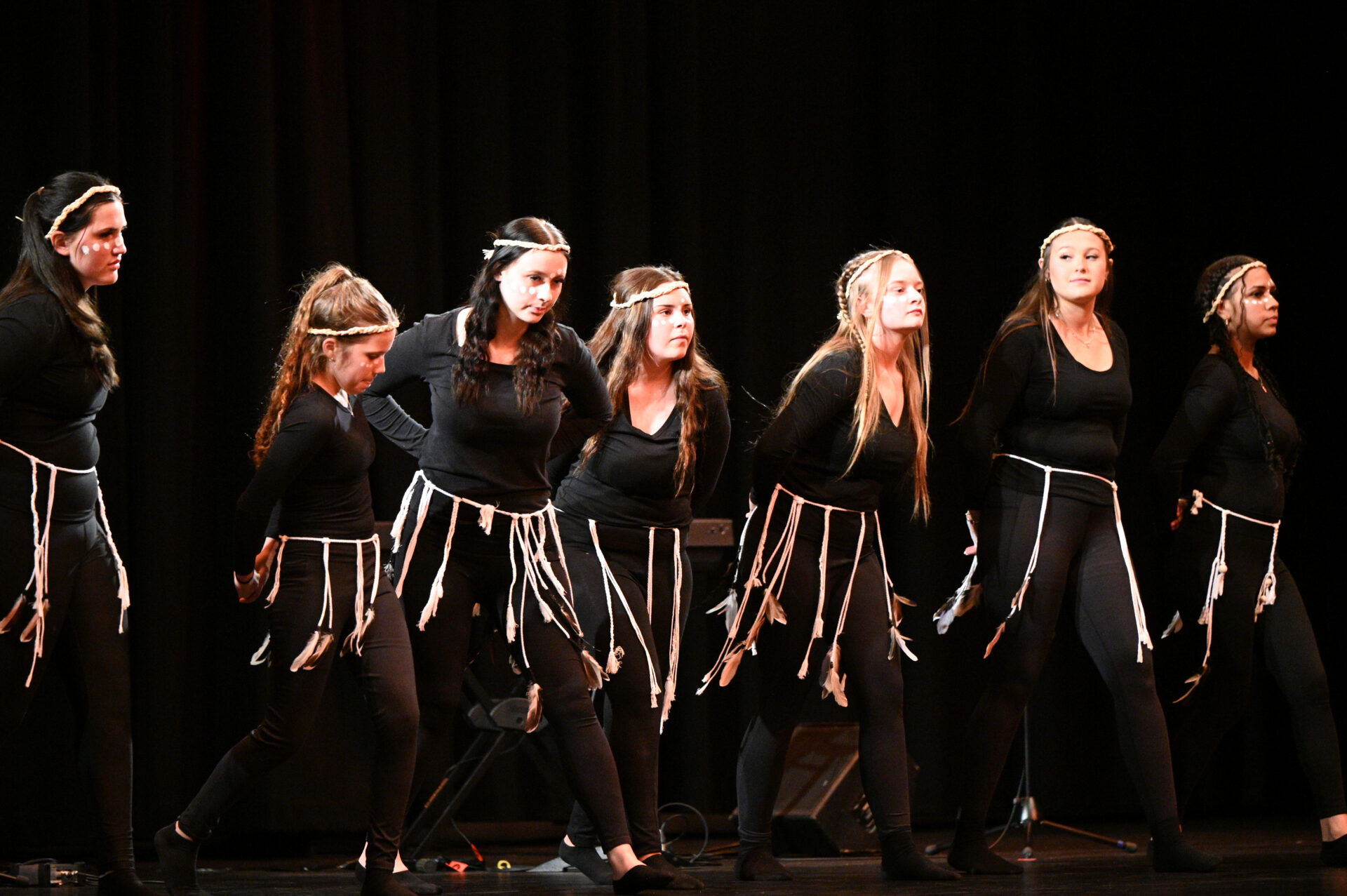 Students performing a dance routine on stage