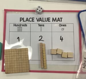 Place value mat with base ten blocks showing the number 124