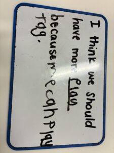 Student whiteboard reading 'I think we should have more play because we can play tag'