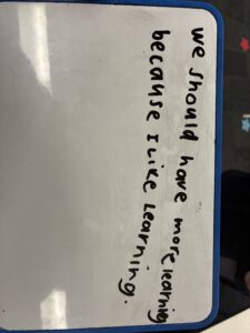 Student whiteboard reading 'We should have more learning because I like learning'