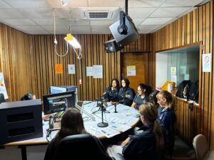 Year 9 Indonesian students seated around the desk in the radio studio