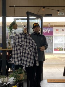 Student volunteering beside a clothing rack in the HOPE Street shop
