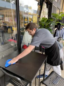 Student wiping down a bench in the HOPE Street kitchen