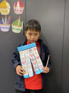 Year 1D student holding their pink and blue Pattern Pants artwork