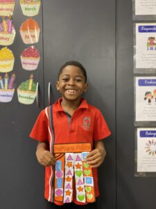 Year 1D student holding their orange and pink Pattern Pants artwork
