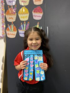 Year 1D student holding their blue Pattern Pants artwork